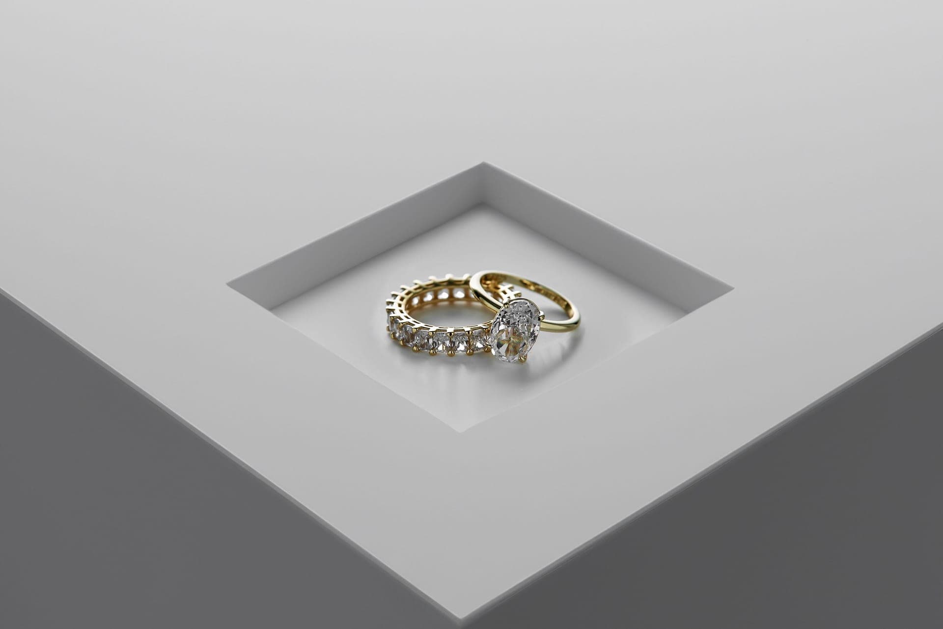 A solitaire ring photographed against a plain pale background