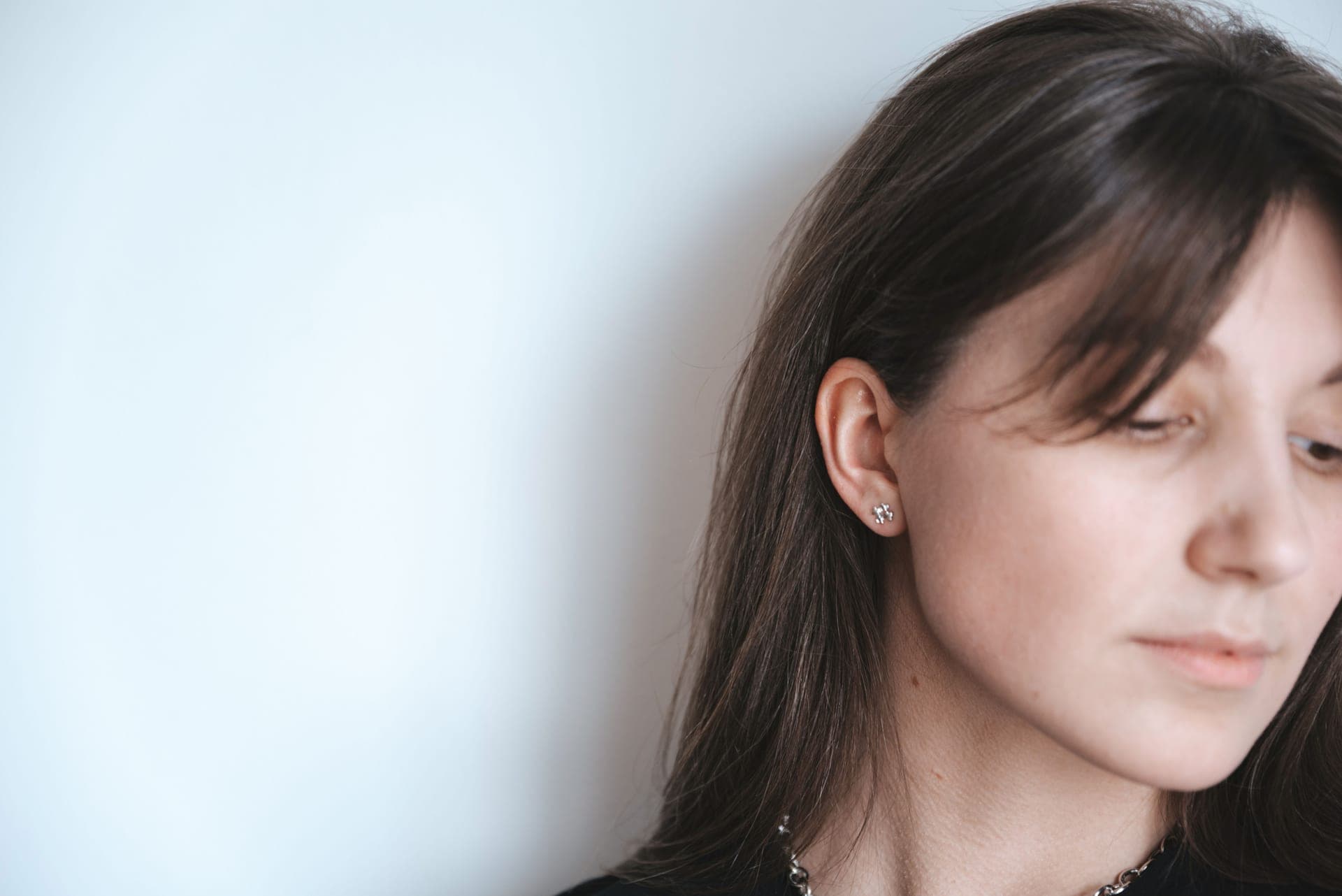 Small silver-toned stud earrings on a pale background